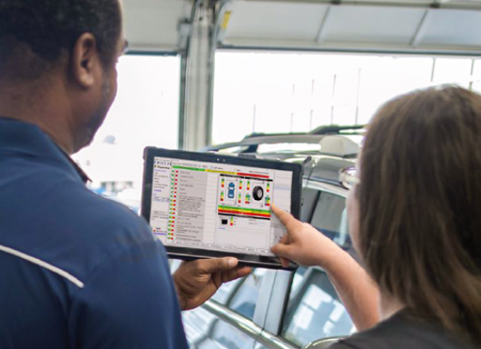 Customer pointing to tablet held by technician