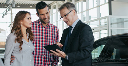 Person talking to couple with a tablet.