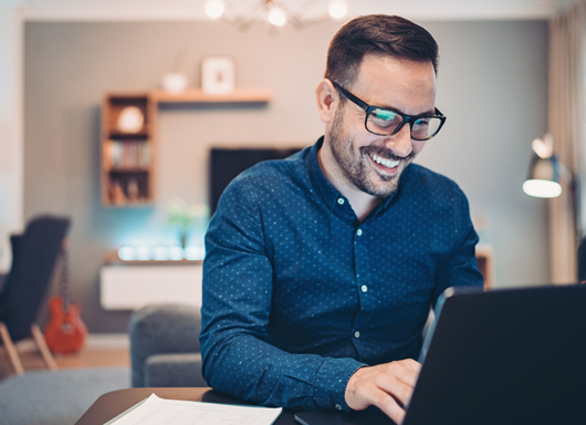 Man smiling and using laptop