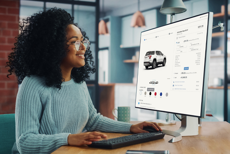 Woman on home computer shopping for SUV