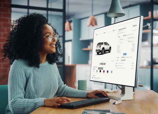 Woman on home computer shopping for SUV.