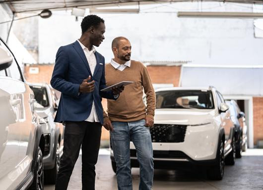 Dealership salesperson with customer in showroom