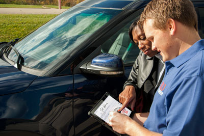 Conseiller du service montrant à un client une inspection multipoint sur une tablette